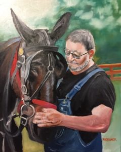 A man with glasses, a beard, and wearing overalls lovingly tends to a large, dark-coated horse with a bridle, set against a blurred green and brown background.