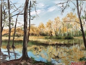 A serene landscape painting depicts a Georgia forest with tall, slender trees by a calm river. The scene is filled with autumn colors, golden leaves reflecting in the water, characteristic of the regions wetlands, and a partly cloudy sky above.