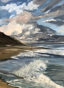 A painting of Lecount Hollow Beach captures waves crashing onto the shore. The sky is filled with dramatic clouds, while two tiny figures stroll near the distant cliffside.