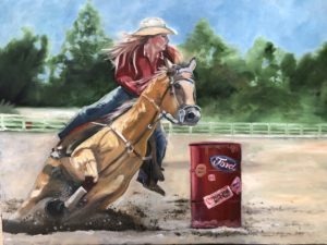 A person in a cowboy hat and red shirt is participating in The Crossing, skillfully riding a tan horse around a barrel marked Ford at the rodeo event. The scene is set against the backdrop of green trees and a clear blue sky.