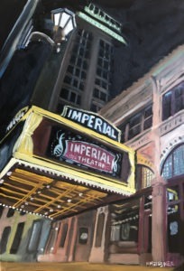 A nighttime scene of the Imperial Theatre in Augusta, GA, showcases its brightly lit marquee displaying the theaters name in white. The building’s illuminated façade highlights architectural details, while a streetlamp casts a warm glow above.