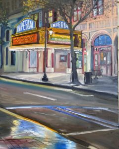 Painting of a street scene with a brightly lit theater marquee reading Imperial. The street and sidewalk glisten with rain reflections, reminiscent of the historic charm of Dorn Mill, while trees line the street, adding a cozy ambiance.