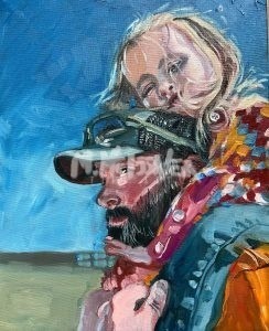 In the painting Dakota and Audrey, Dakota, a bearded man in a hat, carries the blonde-haired child Audrey on his shoulders. She leans forward, her face near his head against a backdrop of a clear blue sky with hints of landscape.